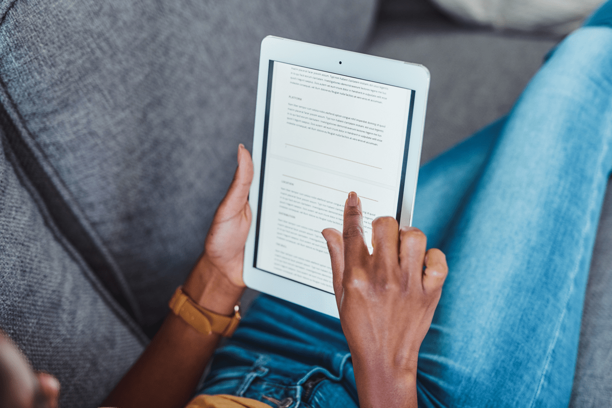 Stock image of someone reading on a tablet.