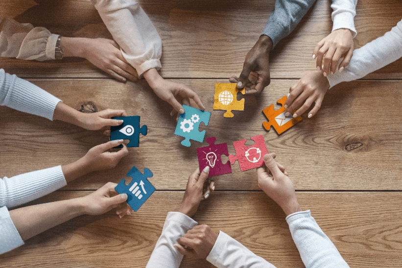 Stock image of many hands with different puzzle pieces.