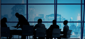 Stock photo of a round table silhouetted in front of a window.