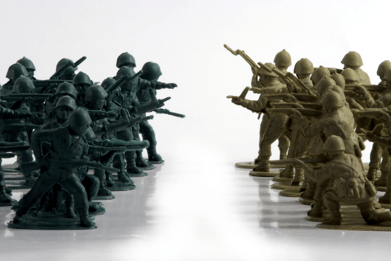 Stock image of toy soldiers split into two colours, facing eachother down.