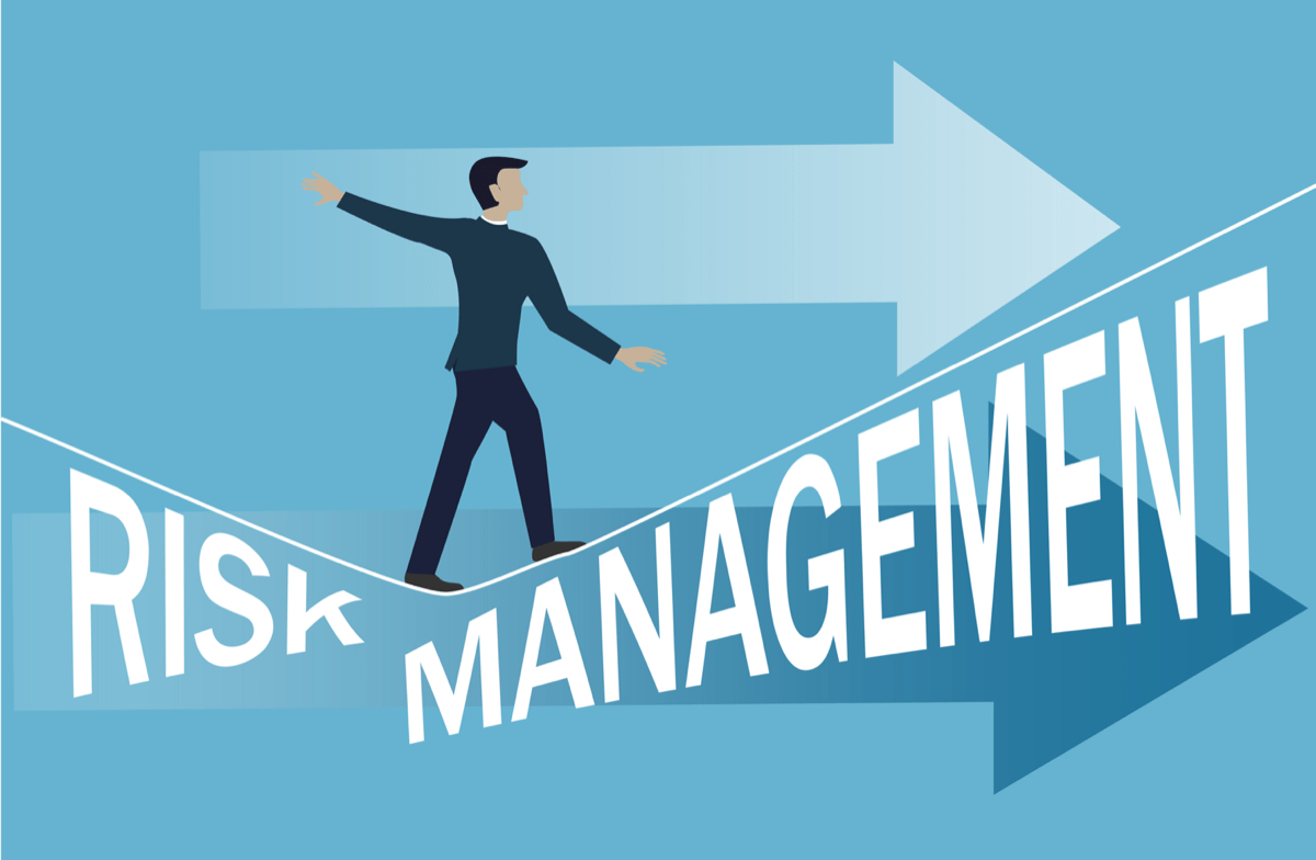 Stock image of a professional walking an uneven line over the words 'Risk Management'.